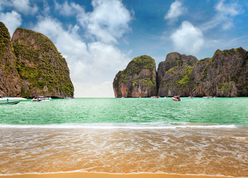 A beach with two boats in the water